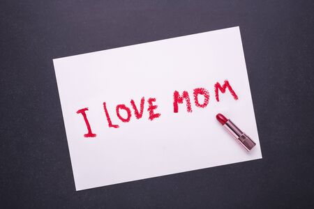 I LOVE MOM writing from red lipstick in white paper on black stone backgroundの写真素材