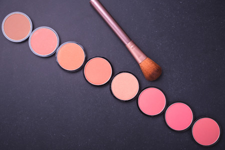 Set of decorative cosmetics and soft brush on stone background