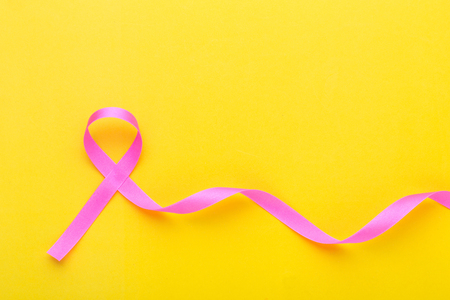 Breast Cancer concept : Pink ribbon symbol of breast cancer on yellow backgroundの写真素材