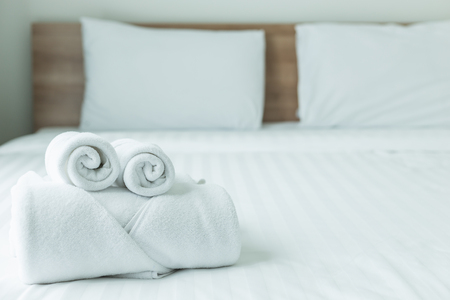 Close up Roll of white towel on the bed table in Luxury modern hotel roomの写真素材