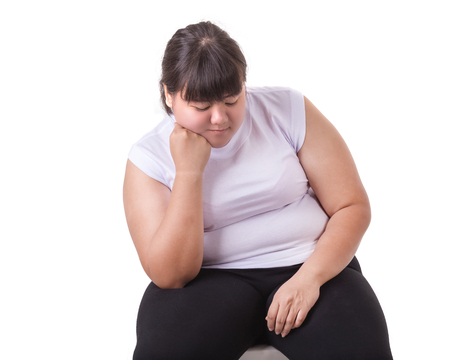 Fat Asian woman wear white t-shirt worried about her body size  isolated on white backgroundの写真素材