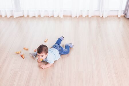 Caucasian children playing toys alone on the floor in the room. Family conceptの写真素材