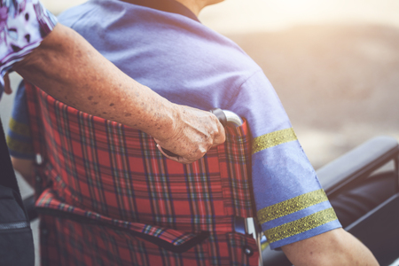 Close up hand of old people on wheelchair of disabled peopleの写真素材