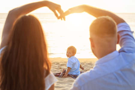 Family on the beach concept, One caucasian boy siting and holding sand on the tropical beach in...