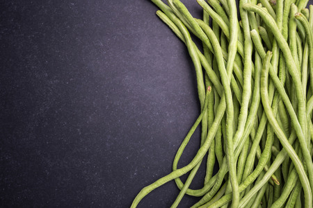 Top view fresh green cowpea or Asparagus bean on black stone backgroundの写真素材