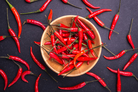 Top view fresh red hot chilli on black stone board backgroundの写真素材