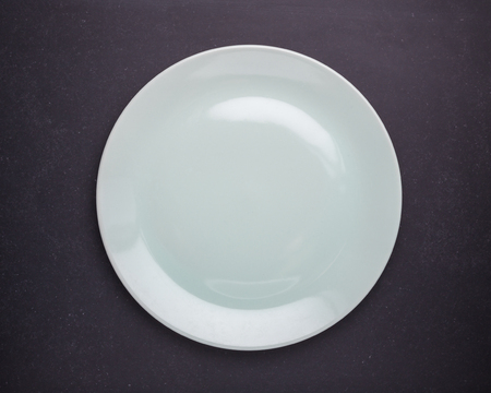 Top view empty white new ceramic kitchen dish on black stone table background