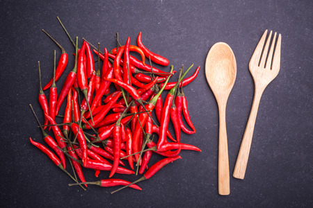 Top view fresh red hot chilli on black stone board backgroundの写真素材