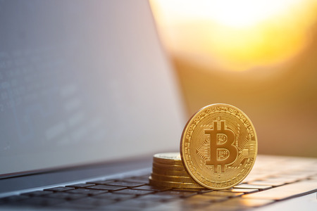 Macro bitcoin. Golden coin with bitcoin symbol on laptop computerの写真素材