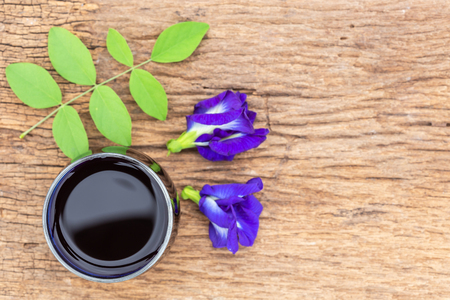 Top view Fresh purple Butterfly pea or blue pea flower and juice in glass on wooden table backgroundの写真素材