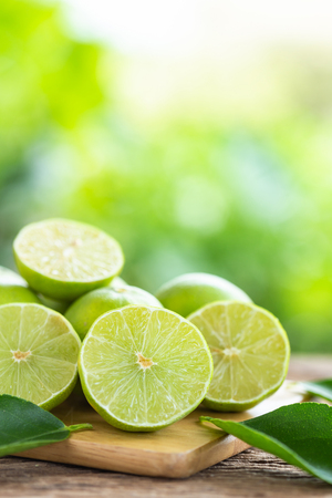 Close up slice green fresh lemon on wooden table backgroundの写真素材