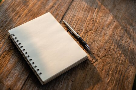 Top view of white book on old wooden plank background with morning nature sunlight