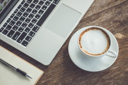 White ceramic coffee cup on wooden table or counter with morning nature light in garden conceptの写真素材