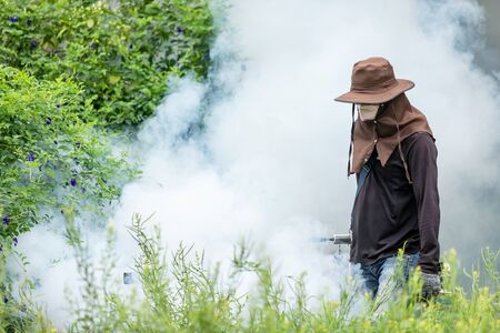 Mosquito repellent concept : A man fogging chemical to eliminate mosquito at the street