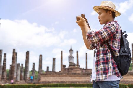 Asian tourist man taking photo in Sukhothai historical park, Northern of Thailandの写真素材