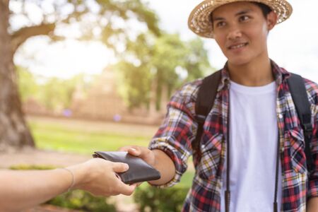 Asian tourist picking up his black wallet from other people that they found in tourist attraction....