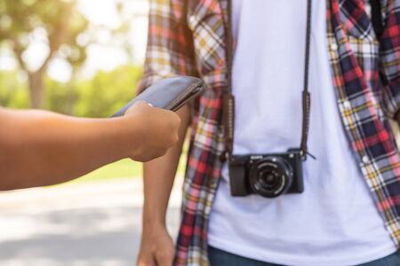 Asian tourist picking up his black wallet from other people that they found in tourist attraction. Losing wallet conceptの写真素材
