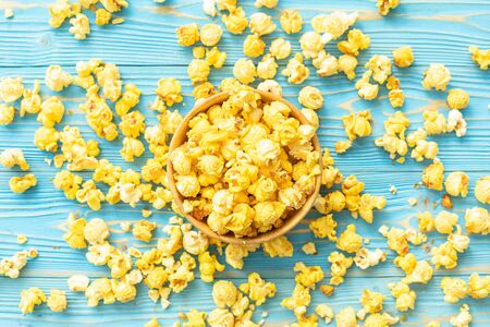 Top view yellow popcorn on blue wooden plank background. Food or snack conceptの写真素材