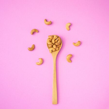 Top view fried cashew nut with salt on pink background. Copy space for text or design. Food conceptの写真素材