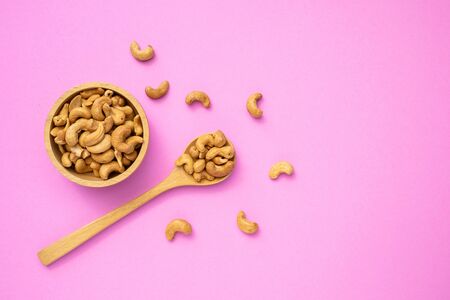Top view fried cashew nut with salt on pink background. Copy space for text or design. Food conceptの写真素材