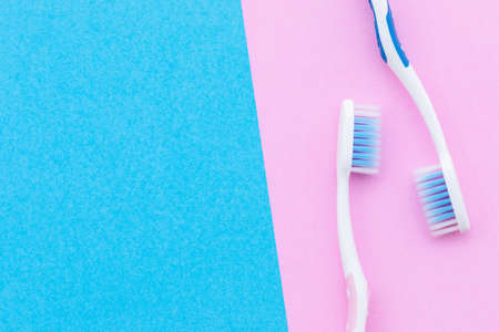 Top view new pink and blue toothbrush on pink background with copy space for text or design.の写真素材
