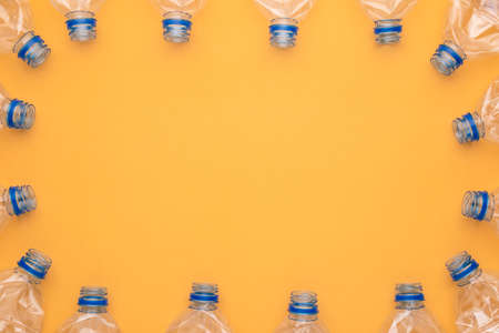 Top view old clear plastic water bottle on yellow backgroundの写真素材