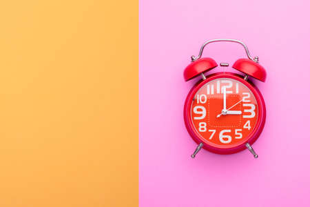 Top view old red alarm clock on bright color backgroundの写真素材
