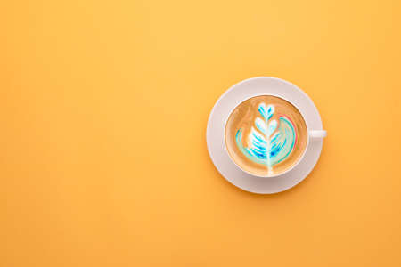 Top view white cup of hot Latte art coffee on yellow background