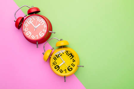 Top view old red and yellow alarm clock on bright color background