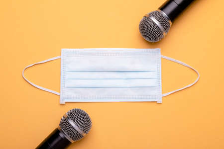 Still keep wearing mask while speak. Top view new preventive face mak and black wireless microphone...