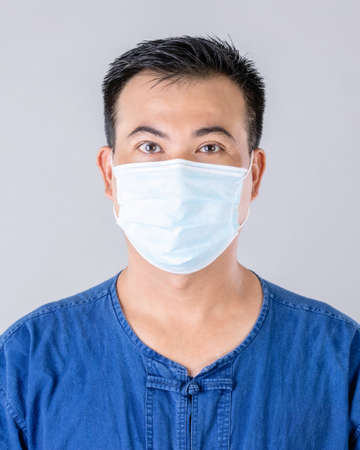 Portrait of Thai farmer wearing protective face mask to prevent virus studio shot on grey backgroundの写真素材