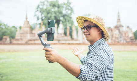 Asian tourist working and using laptop at Sukhothai historical park, Thailand. Vacation and holiday...