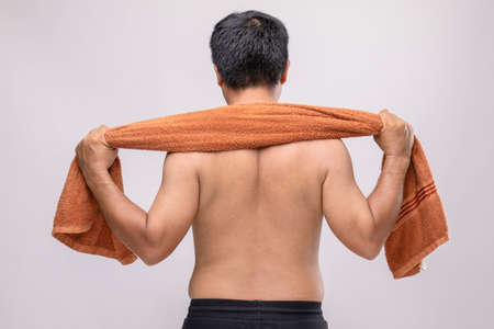 Close up man holding towel to rub the body dry after shower. To used wet towel can be the dermatitis on the body concept. Studio shotの写真素材