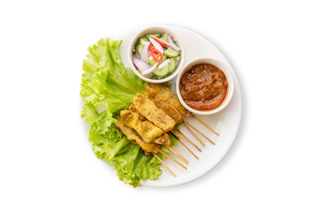 Top view. Pork Satay with Peanut Sauce and pickles which are cucumber slices and onions in vinegar. Isolated on white backgroundの写真素材
