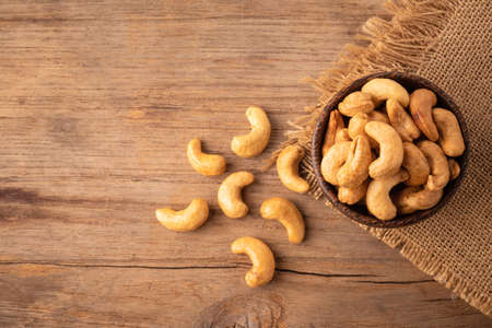 Top view pile of roasted cashew nut in bowl on the table background. Food concept. Focus on bowlの写真素材