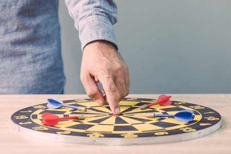 Businessman working in the office and point in the center of yellow dartboard. Goal and success for business concept.の写真素材