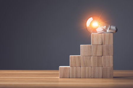 Finding the new inspiration concept, Light bulb put on top of wooden block stacked on wooden table. Use for the idea of future creative innovation, Learning, Education or working Concept, Studio shot.の写真素材