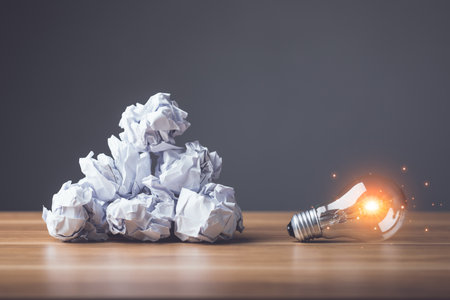 Finding the new inspiration concept, Light bulb with white used and crumpled paper on wooden table. Use for the idea of future creative innovation, Learning, Education or working, Studio shot.の写真素材
