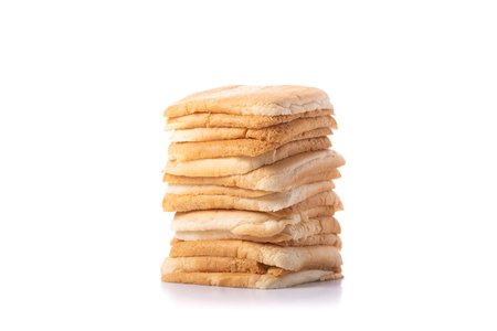 Slices of bread stacked on a gray wooden table against a isolated white background. The image...