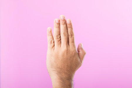 Hand displays various gestures, including a fist, open palm, and raised fingers, against a pink background. A visual exploration of communication through hand symbolsの写真素材