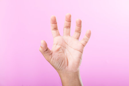 Hand displays various gestures, including a fist, open palm, and raised fingers, against a pink background. A visual exploration of communication through hand symbolsの写真素材