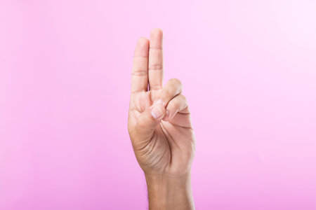 Hand displays various gestures, including a fist, open palm, and raised fingers, against a pink background. A visual exploration of communication through hand symbolsの写真素材