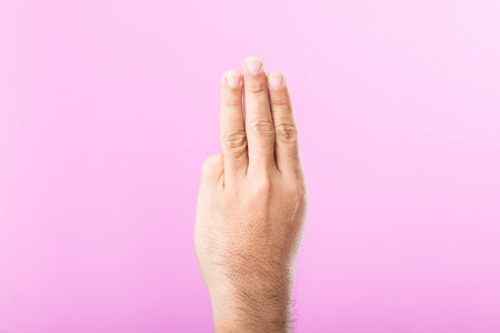 Hand displays various gestures, including a fist, open palm, and raised fingers, against a pink background. A visual exploration of communication through hand symbolsの写真素材