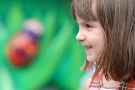 Profile of a happy young child playing in park