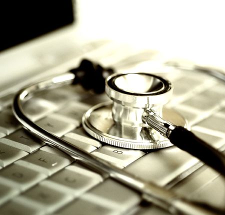 Silver stethoscope over laptop keyboard