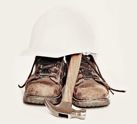 Old worn work boots, hammer and helmet の写真素材