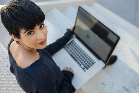 Young woman using laptop - looking upの写真素材