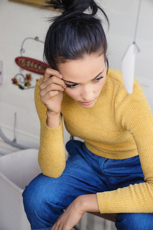 Woman in contemplative mood wearing jeans and top, nostalgic mood.の写真素材