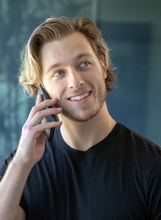 Man smiling while talking on cell phone