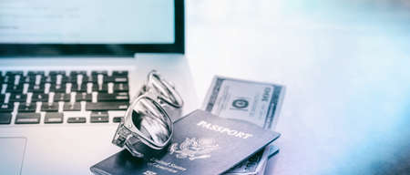 Laptop Computer, Travel Documents - USA Passport with American Currency, Business travel concept...
